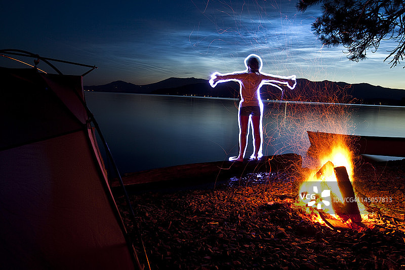 在爱达荷州湖岸露营的瑜伽女子光绘图片素材