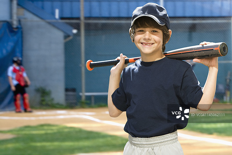 白人男孩在球场上手持棒球棒图片素材