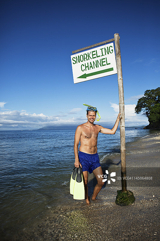 在沙滩上拿着脚蹼的浮潜者图片素材