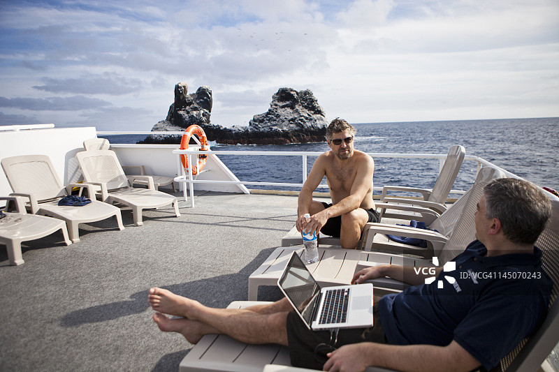 两名男子在船的甲板上放松身心图片素材