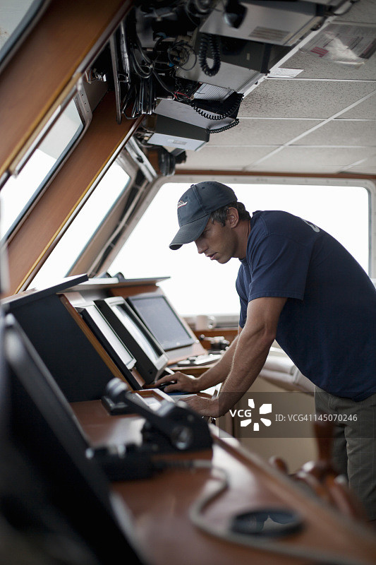 在船的驾驶舱工作的船长图片素材