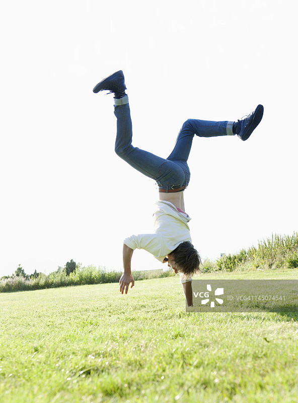 男人在草地上倒立图片素材