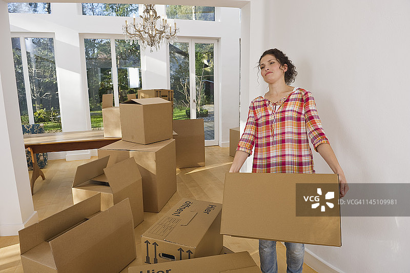 德国巴伐利亚格罗本策尔：中年妇女在房子里搬运纸箱图片素材