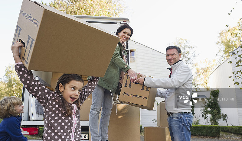 德国巴伐利亚格罗本策尔一家人搬家时抱着纸箱微笑图片素材
