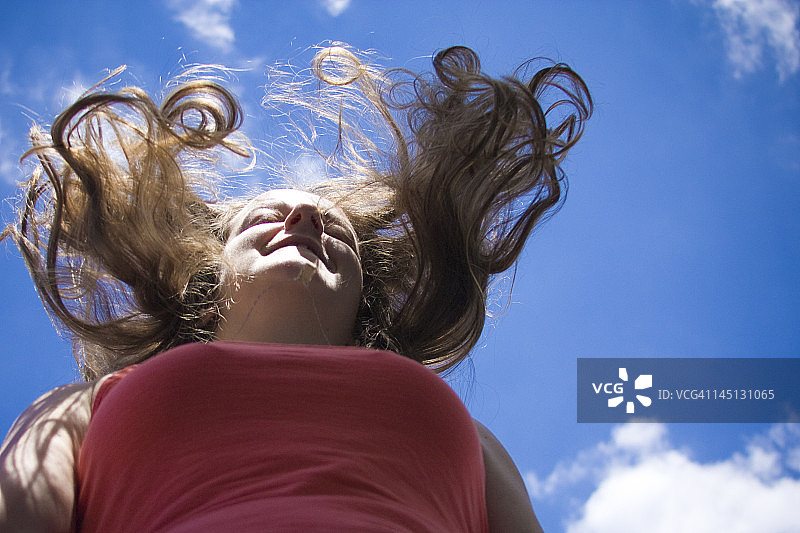 在天空下跳跃的金发女孩图片素材