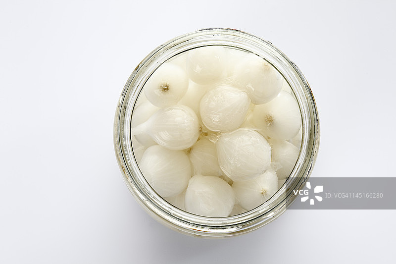白色背景下玻璃罐中的银皮洋葱图片素材