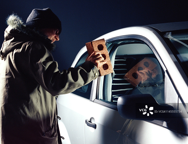 小偷用砖头砸碎汽车车窗图片素材