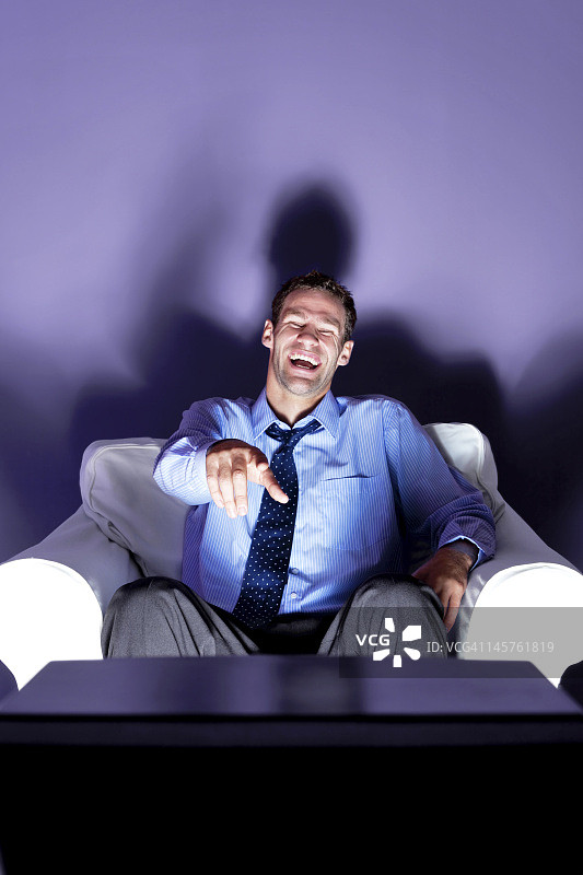 男人笑着看电视图片素材