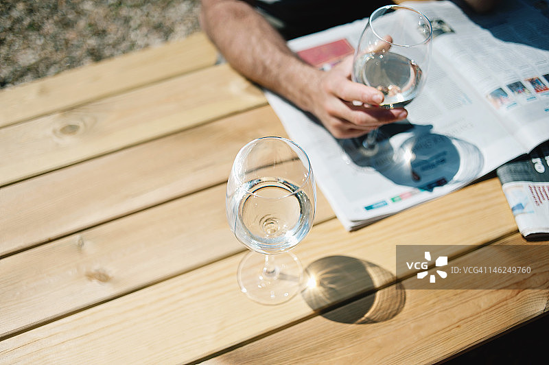 男人拿着酒杯读报纸图片素材