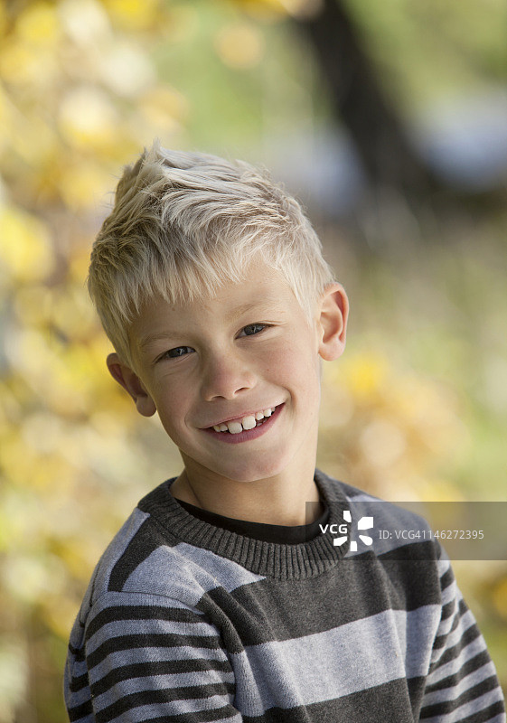 在户外微笑的金发男孩肖像图片素材