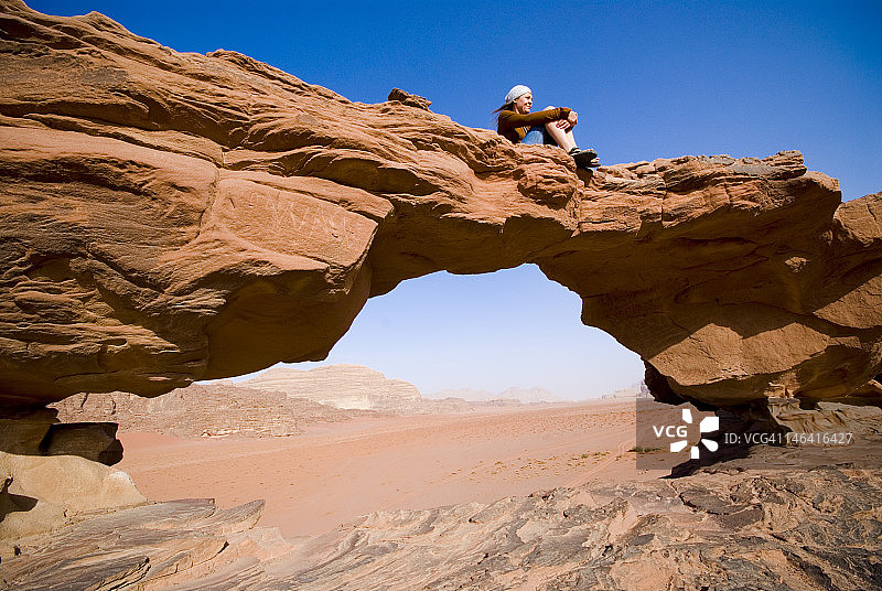 坐在岩石拱门上的女人图片素材