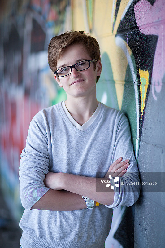 倚靠在涂鸦墙上的男孩图片素材