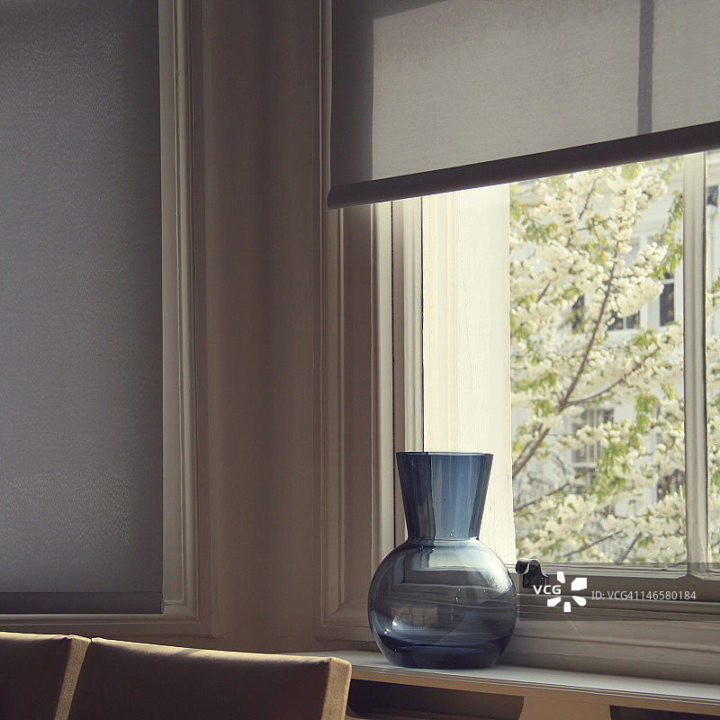 窗边的白色花朵和蓝色花瓶图片素材