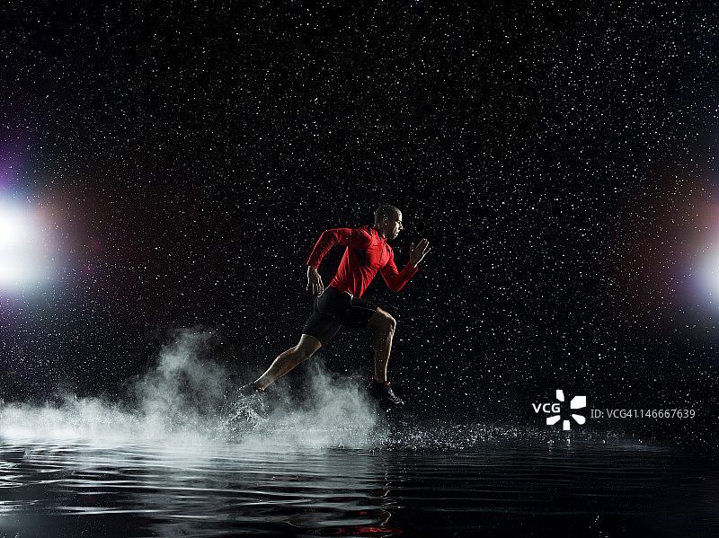 运动员在雨夜中涉水奔跑图片素材