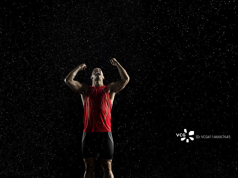 雨中举起双臂庆祝胜利的运动员图片素材