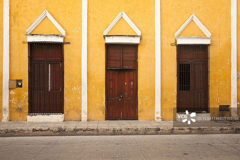 黄色墙上的三个门口图片素材