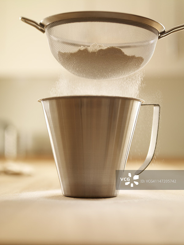 面粉被筛入量杯中图片素材