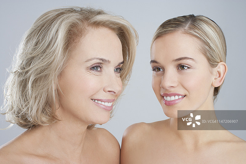 微笑的赤裸上身的母亲和女儿肖像图片素材