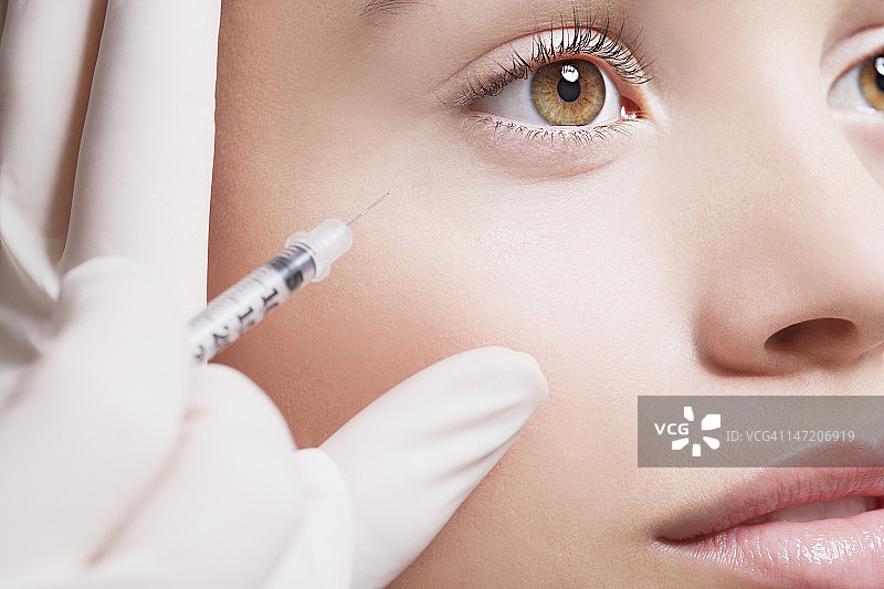 女人接受眼部肉毒杆菌注射特写镜头图片素材