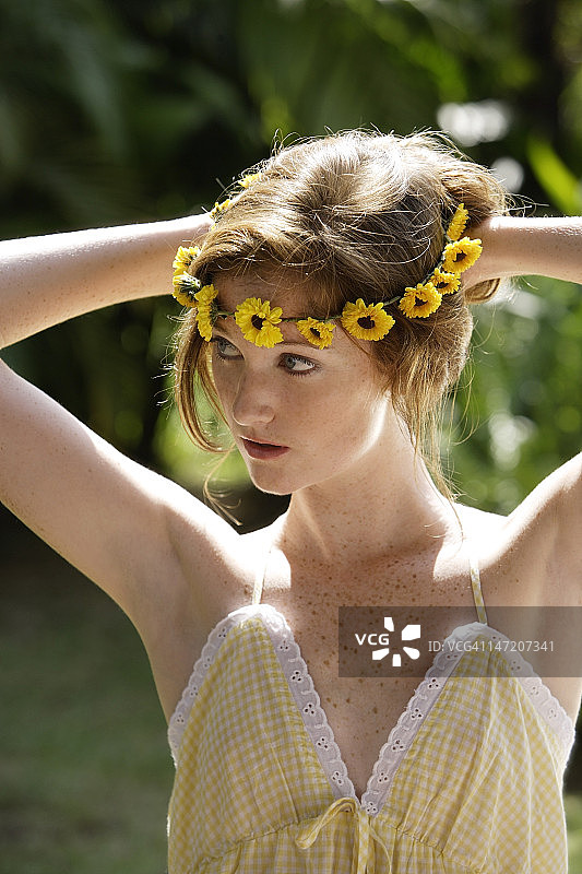 年轻女人在头发上系雏菊花环图片素材