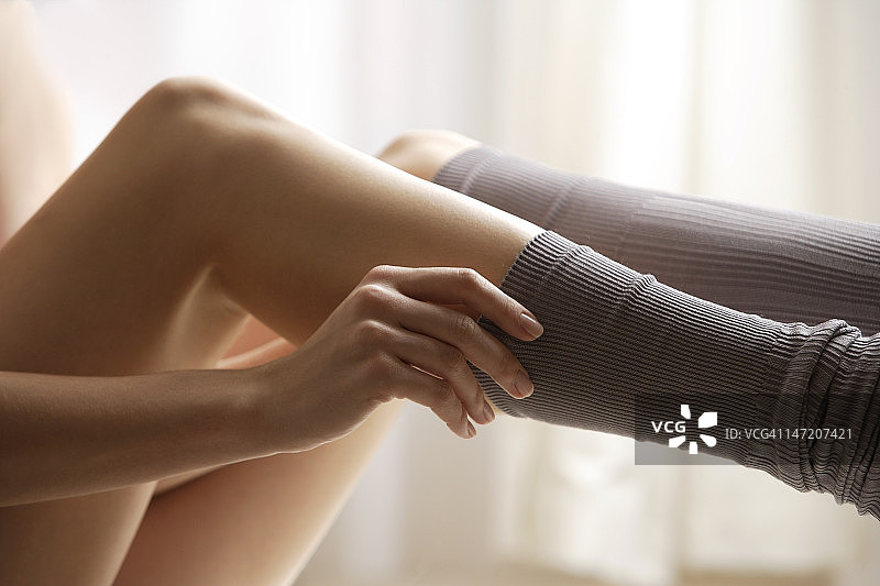 提袜子的年轻女人图片素材