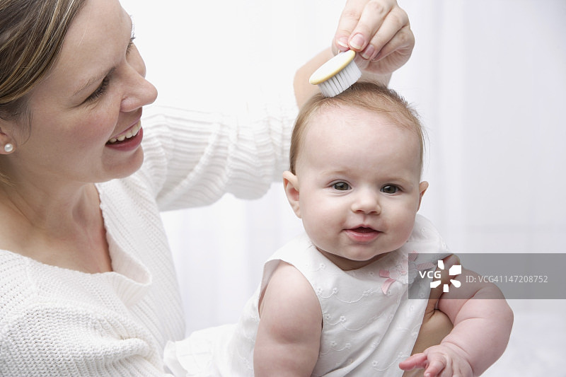 母亲给宝宝梳头图片素材