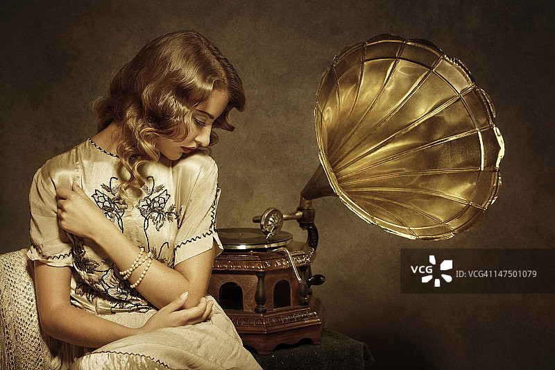 复古风格的女人用留声机听音乐图片素材