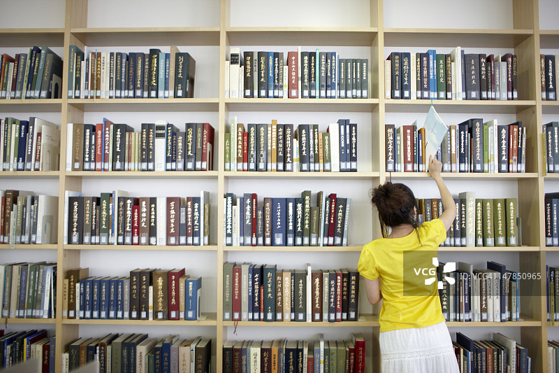 在图书馆选书的女学生图片素材
