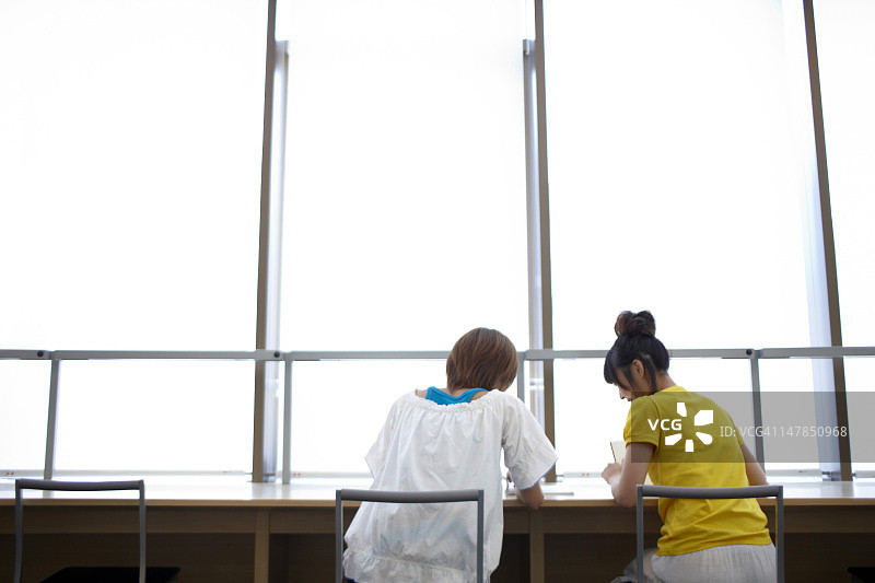 在图书馆阅读的两个女学生图片素材