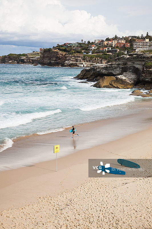 冲浪者在海滩奔跑图片素材
