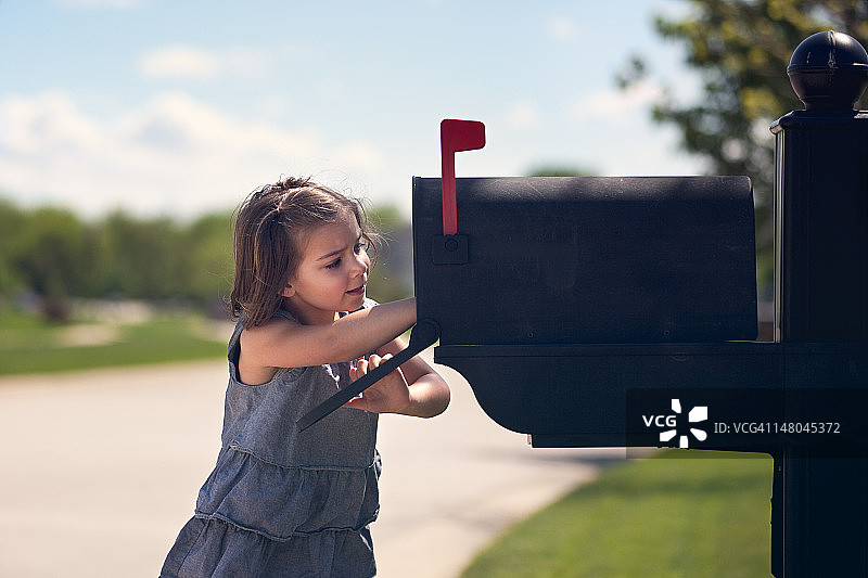 女孩将信件投入邮箱图片素材