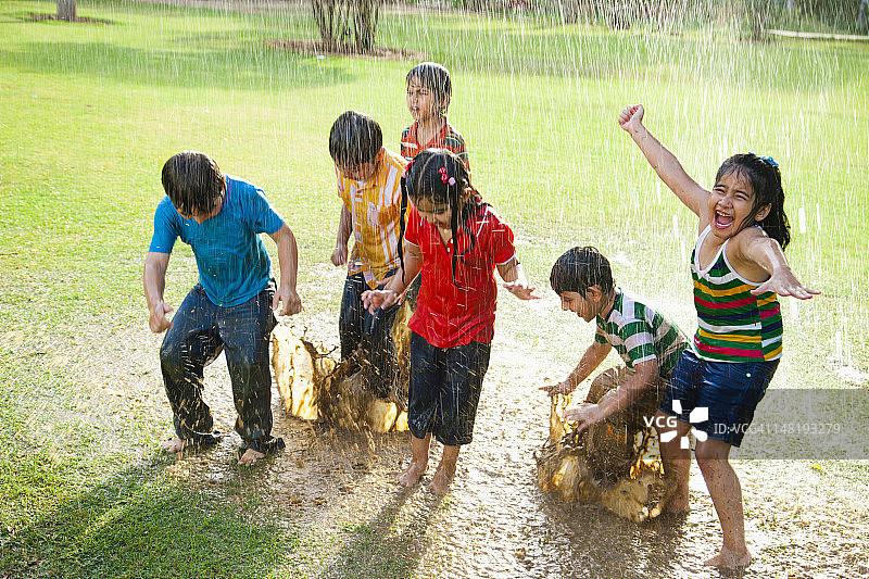 4-7岁儿童在水坑里玩耍图片素材