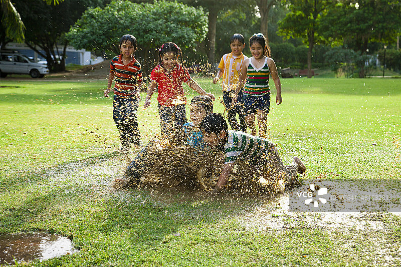 4-7岁儿童在水坑里玩耍图片素材