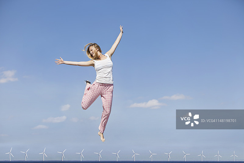 女人为风力涡轮机欢呼雀跃图片素材