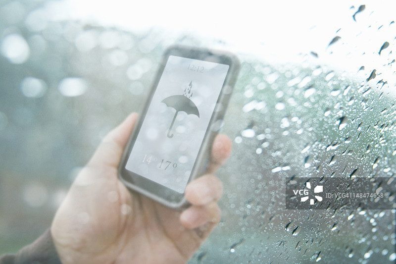 雨水浸润的窗户后的手机天气预报图片素材