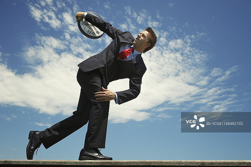 商人准备掷铁饼时钟图片素材