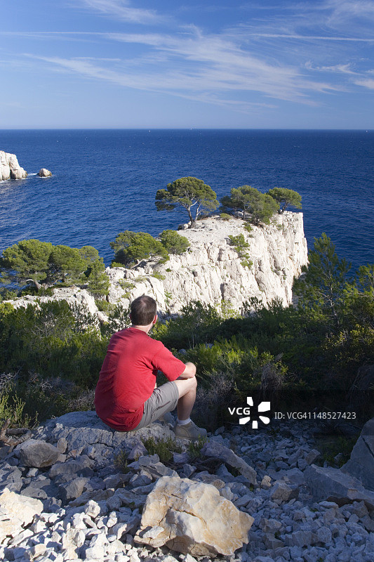 男人眺望昂沃角海景，石灰岩岬角，位于波尔潘峡湾和昂沃峡湾之间图片素材