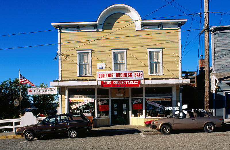前街店铺和停放的车辆。图片素材