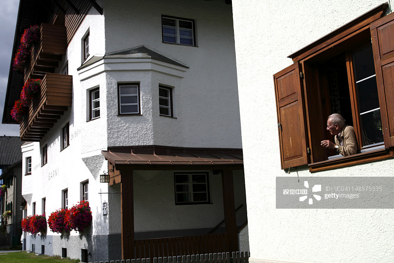 男人从沿街的房子里向窗外看图片素材