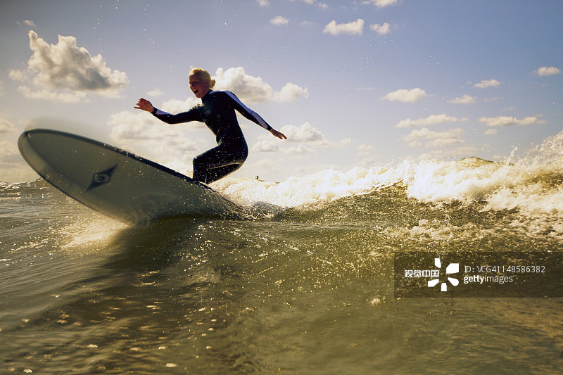 在海浪上玩长板冲浪的女孩图片素材