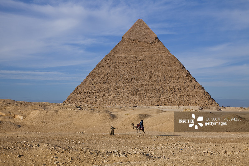 游客骑骆驼经过吉萨的哈夫拉金字塔图片素材