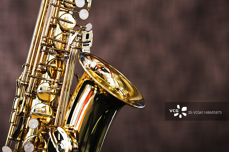 棕色背景上闪亮的萨克斯管特写图片素材