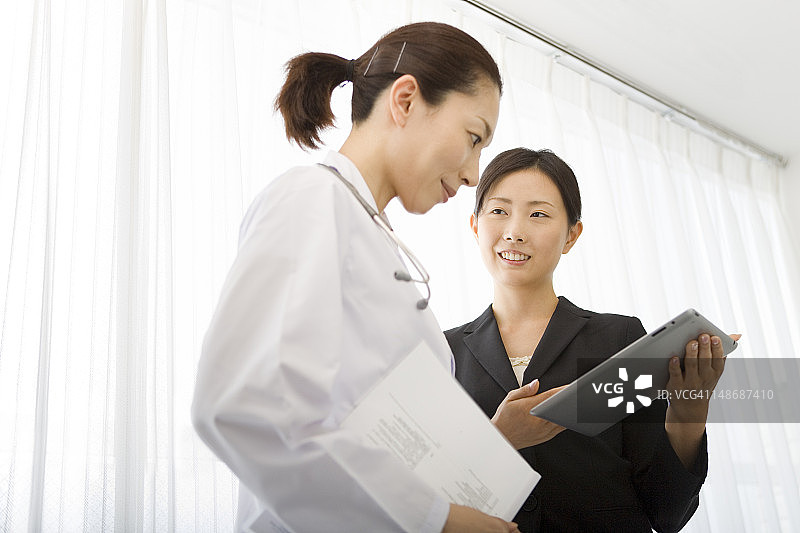 医药销售代表向女医生展示平板电脑图片素材