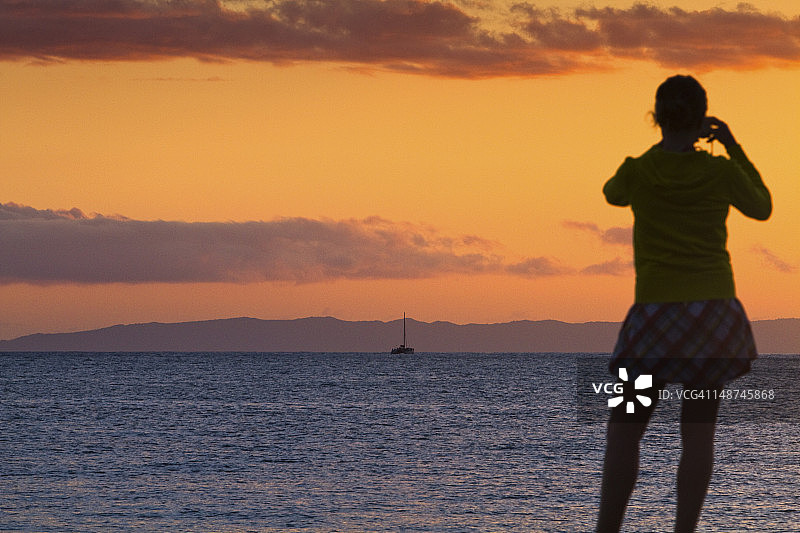 摄影师在日落时拍摄尼豪岛图片素材