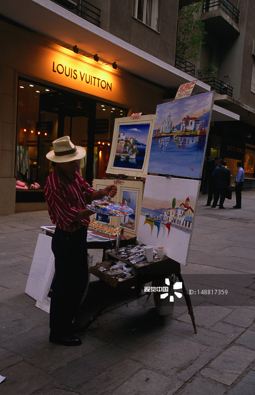 街头艺术家在画布上为游客绘制风景图片素材