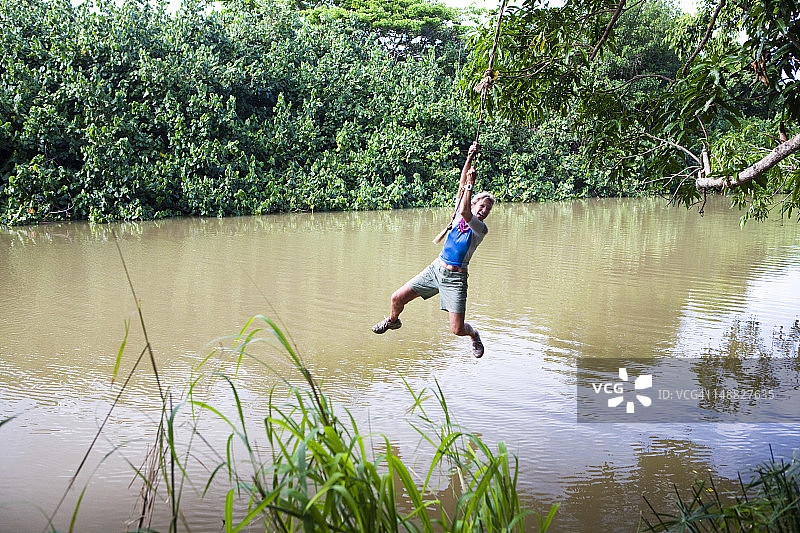 女人在Huleu00c3u00a6ia河上荡绳索图片素材