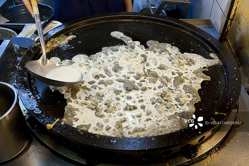 女人在士林夜市的摊位上准备食物图片素材