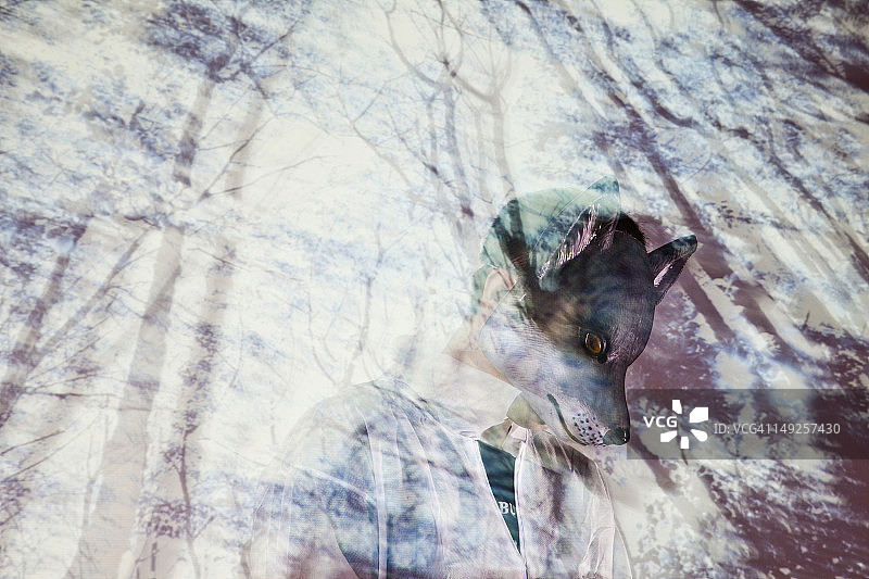 戴着狼面具，背景是树木投影的男人图片素材