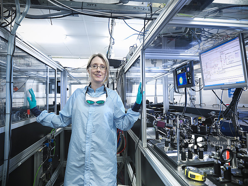 通过显示器观察激光束轮廓和LabView代码的女科学家肖像图片素材