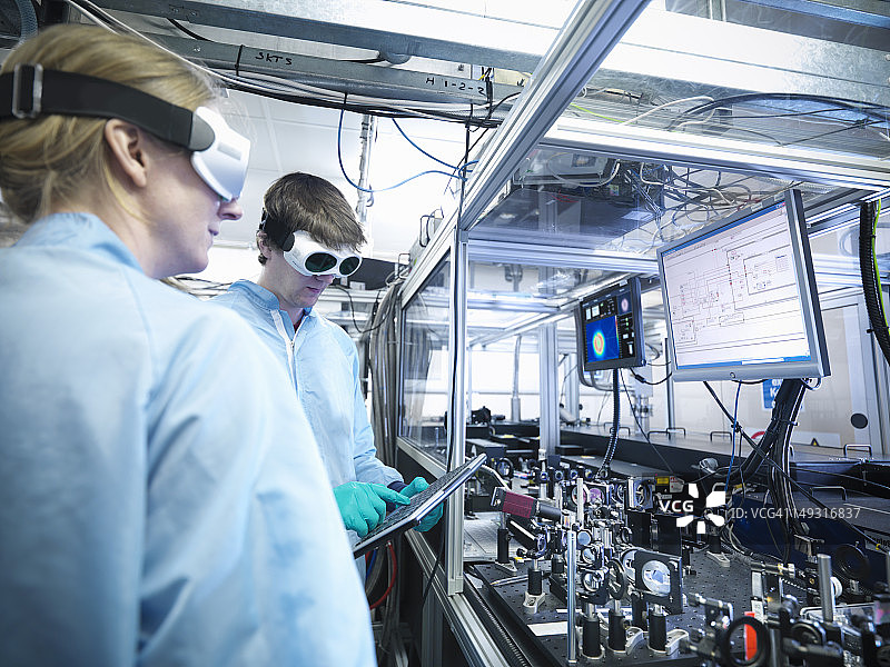 科学家通过显示器观察激光束轮廓和LabView代码图片素材